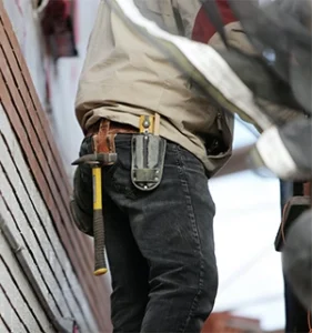 Builder with hammer hanging from belt